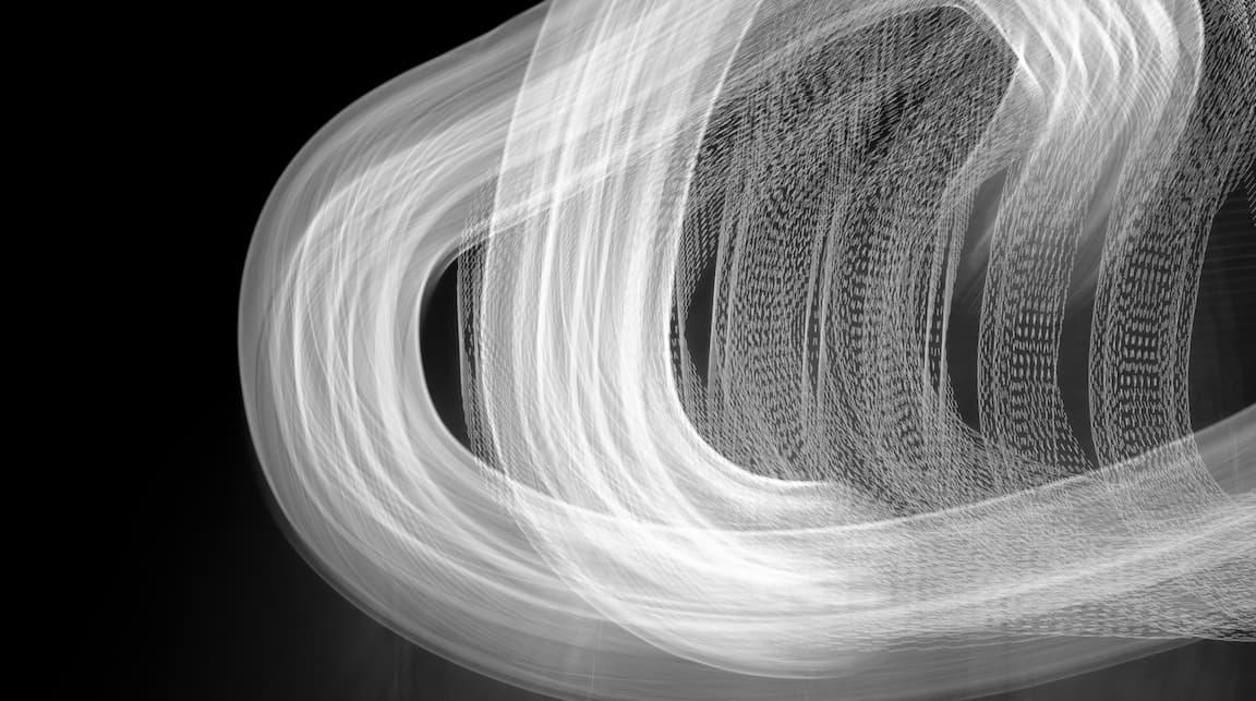 Abstract black and white light painting with curved and vertical streaks on a dark background.